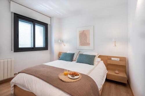 a bedroom with a bed with a tray of food on it at Sitges Centre. Simply Charming in Sitges