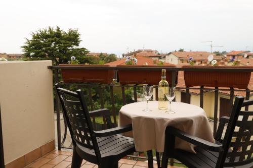 a table with two glasses of wine on a balcony at Hotel da Roberto in Lazise