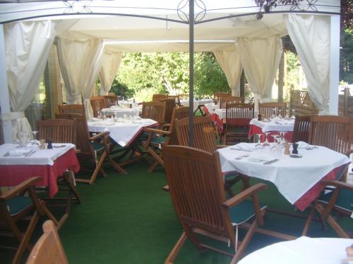 a restaurant with tables and chairs with white tablecloths at Hôtel Auberge de La Nauze in Sagelat