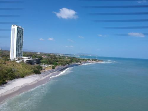 an aerial view of a beach with a tall building at Apartamento El Palmar Residences in San Carlos