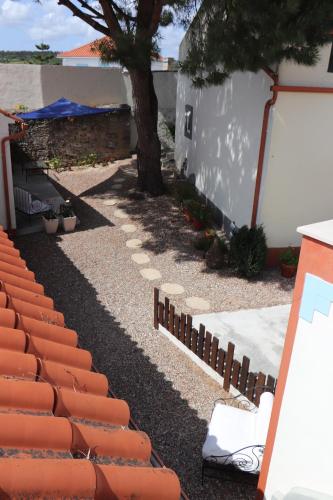 a garden with a fence and a tree next to a building at Casa o Futuro in Alcobaça