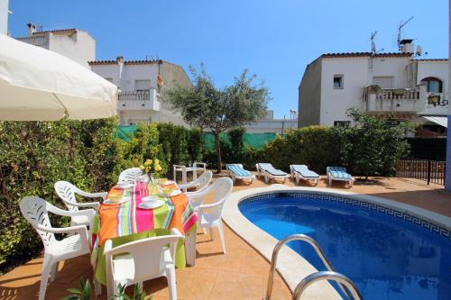 a table and chairs next to a swimming pool at Apart-rent Casa con piscina Sant Maurici 0191 in Empuriabrava