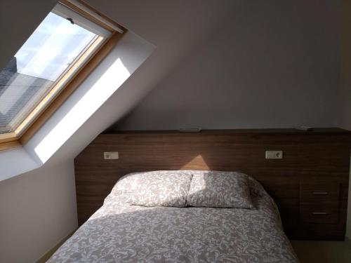 a bedroom with a bed and a window at Ático centro Ribeira by Cristian&Tamara "alquileres" in Ribeira