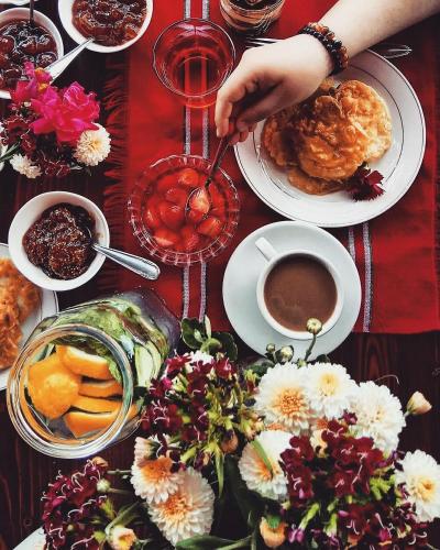 a table topped with plates of food and a person holding a spoon at Timo's Guest House in Berat