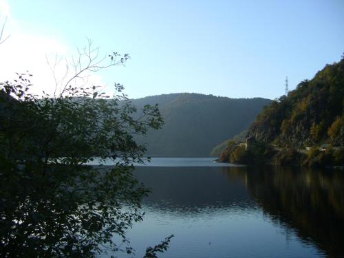 a lake in the middle of a mountain at Pensiunea Popasul Iancului in Mărişel