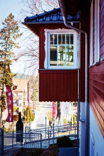 a red house with a window on the side of it at Hotel Willa Odkrywców in Szklarska Poręba