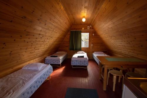 a room with three beds and a table in it at Ranua Resort Camping Ranuanjärvi in Ranua