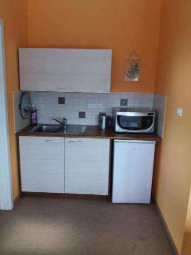 a kitchen with a sink and a microwave at Garden apartments in Znojmo