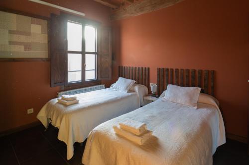 a bedroom with two beds with towels on them at La Casa Azul in Alcanadre