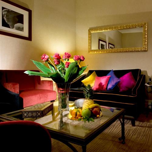 a living room with a table with a vase of flowers at Hotel dei Mellini in Rome
