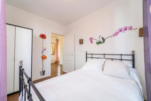 Rilly-la-MontagneにあるGîte Rilly-la-Montagneのベッドルーム1室(花の壁に白いベッド1台付)