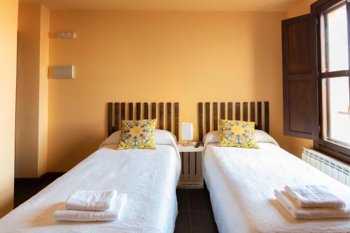 two beds sitting next to each other in a room at La Casa Azul in Alcanadre