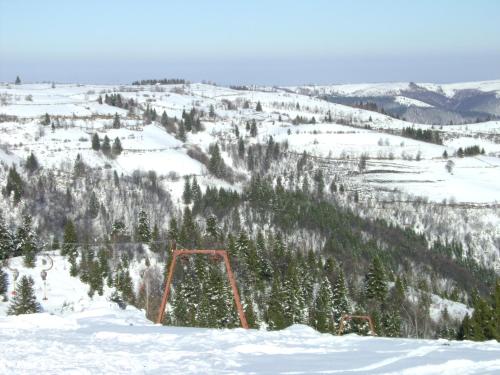 a ski lift in the snow on a mountain at Pensiunea Popasul Iancului in Mărişel