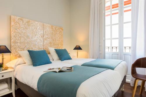 sypialnia z 2 łóżkami i niebieskimi poduszkami w obiekcie Imperial Luxury & Modern Apartment w Sewilli