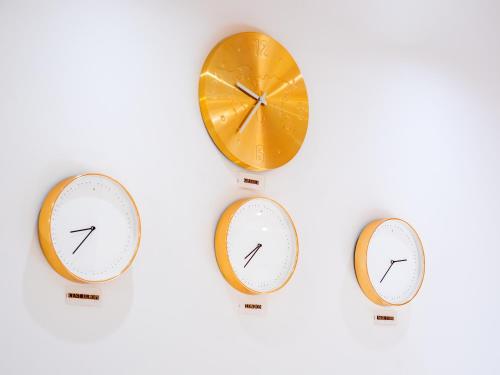 three clocks with different times on them on a white background at CNic Gemini Hotel in Mesongi