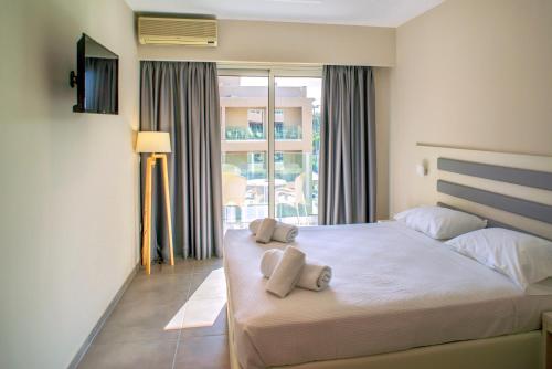 a bedroom with a bed with two towels on it at CNic Gemini Hotel in Mesongi