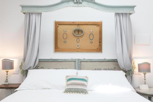 a bedroom with a white bed with a blue headboard at Addimora Boutique Suites in Palermo