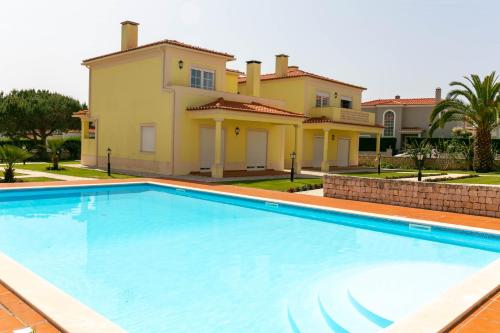 a large swimming pool in front of a house at Apartment - Golf & Beach Resort in Casal da Lagoa Seca