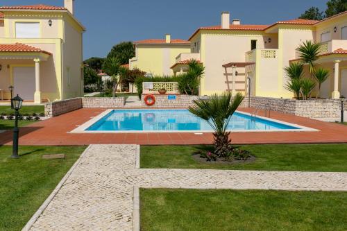 ein Haus mit einem Swimmingpool im Hof in der Unterkunft Apartment - Golf & Beach Resort in Casal da Lagoa Seca