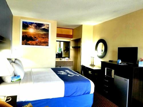 a hotel room with a bed and a television at Days Inn by Wyndham Easley West Of Greenville/Clemson Area in Easley