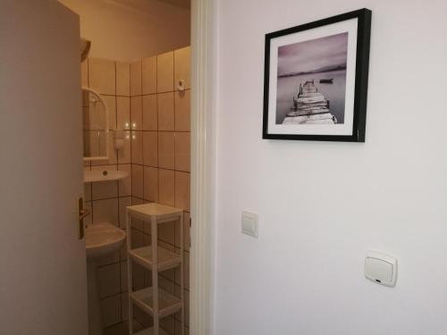 a bathroom with a toilet and a sink with a picture on the door at Ośrodek Wczasowy Daga in Dziwnów