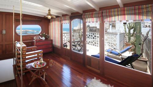 a room with a balcony with chairs and a table at Dar Loulema in Essaouira