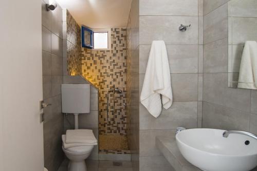 łazienka z białą umywalką i toaletą w obiekcie Evgenia Rooms and Apartments w mieście Chora Folegandros