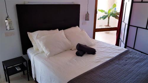 un letto bianco con testiera nera e cuscini bianchi di Torre Vistas Superior a Torremolinos