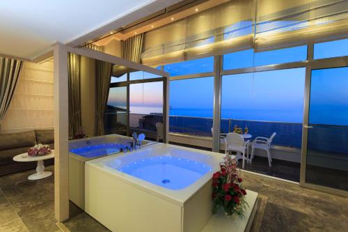 a bathroom with a large tub with a view of the ocean at Xperia Saray Beach Hotel in Alanya