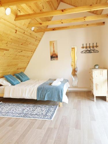 a bedroom with a bed and a wooden ceiling at Vila G Palanga in Palanga