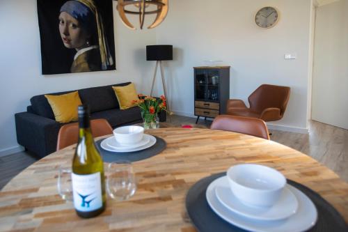 a living room with a table with a bottle of wine at Seapoint - Sea view in Zandvoort