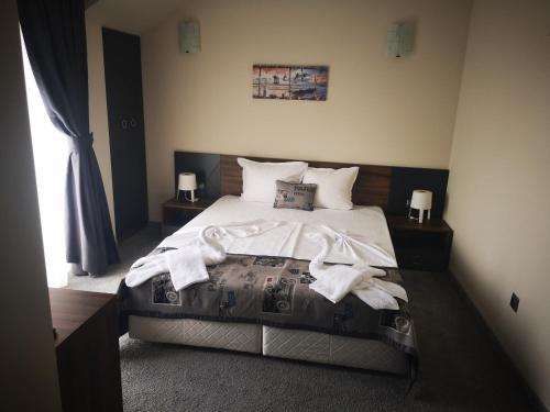 a bedroom with a large bed with towels on it at Family Hotel Novel City in Burgas