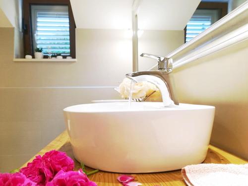 a bathroom sink with a faucet and pink flowers at Villa Lucija Cilipi in Čilipi