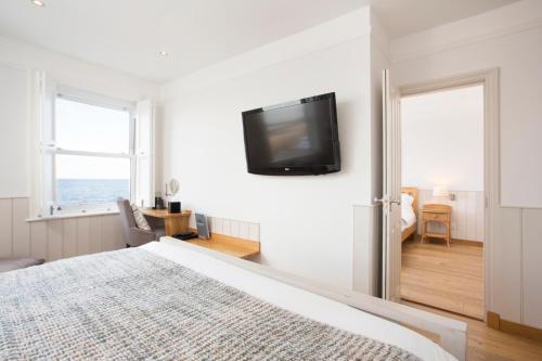 a bedroom with a bed and a tv on the wall at Hotel Continental in Whitstable