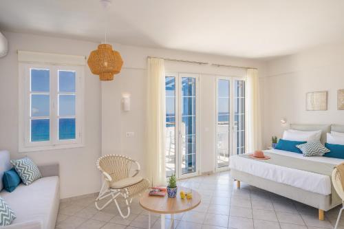 a bedroom with a bed and a couch and a table at Romantica Hotel Apartments in Agia Pelagia Kythira