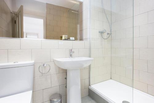 a bathroom with a sink and a toilet and a tub at Hotel Continental in Whitstable