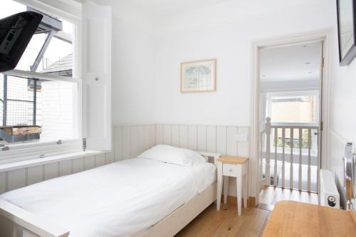 a small bedroom with a bed and a window at Hotel Continental in Whitstable