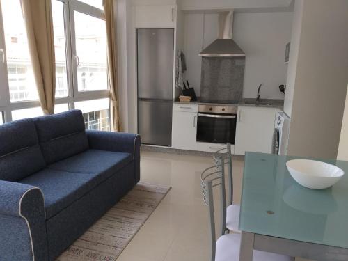 een woonkamer met een blauwe bank en een tafel bij Apartamento en Ribeira(centro) 2* planta in Ribeira