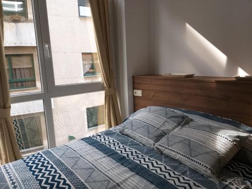 1 dormitorio con cama y ventana en Apartamento en Ribeira(centro) 2* planta en Ribeira