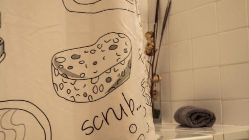 a shower curtain in a bathroom with the words scrummy at Apartamento El Salón in Écija