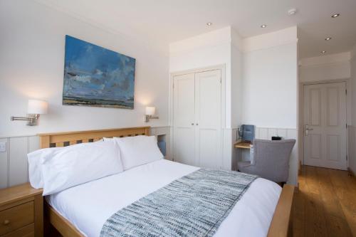 a bedroom with a white bed and a desk at Hotel Continental in Whitstable