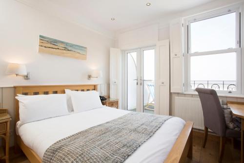 a bedroom with a bed and a desk and a window at Hotel Continental in Whitstable