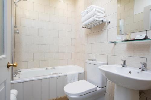 a bathroom with a toilet and a sink and a tub at Hotel Continental in Whitstable