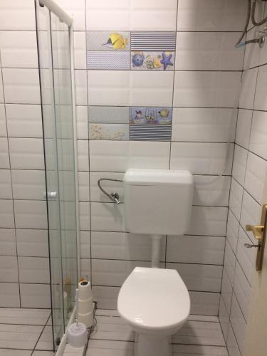 a bathroom with a toilet and a glass shower at Teraszos ház in Balatonlelle