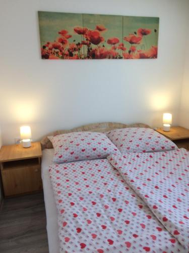 a bedroom with a bed with red flowers on it at Teraszos ház in Balatonlelle