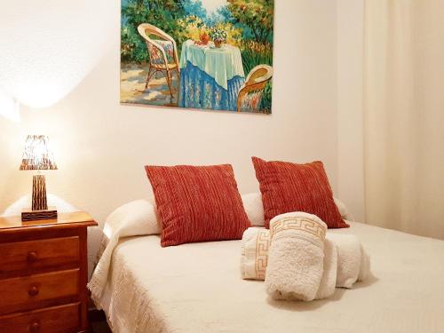 Apartamento turístico en Sevilla في إشبيلية: غرفة نوم بسرير مع لوحة على الحائط