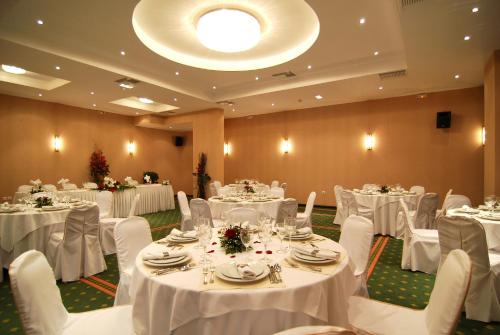 
a white table topped with white tables and chairs at Palatino Hotel in Zakynthos
