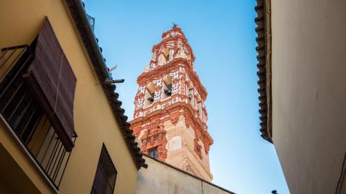 a tall tower with a clock on top of a building at Apartamento El Salón in Écija