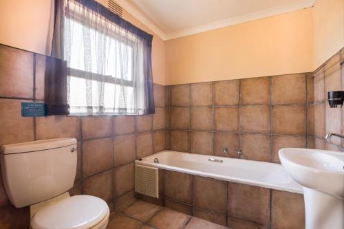 Un baño con inodoro, bañera y lavabo. en Sedgefield Island Holiday House, en Sedgefield