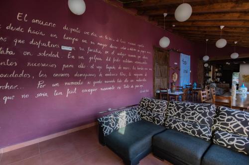 a couch against a wall with writing on it at La Casa Azul in Alcanadre